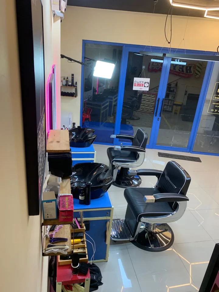 Deretan kursi dan wastafel keramas HEYBOY di dekat pintu kaca biru